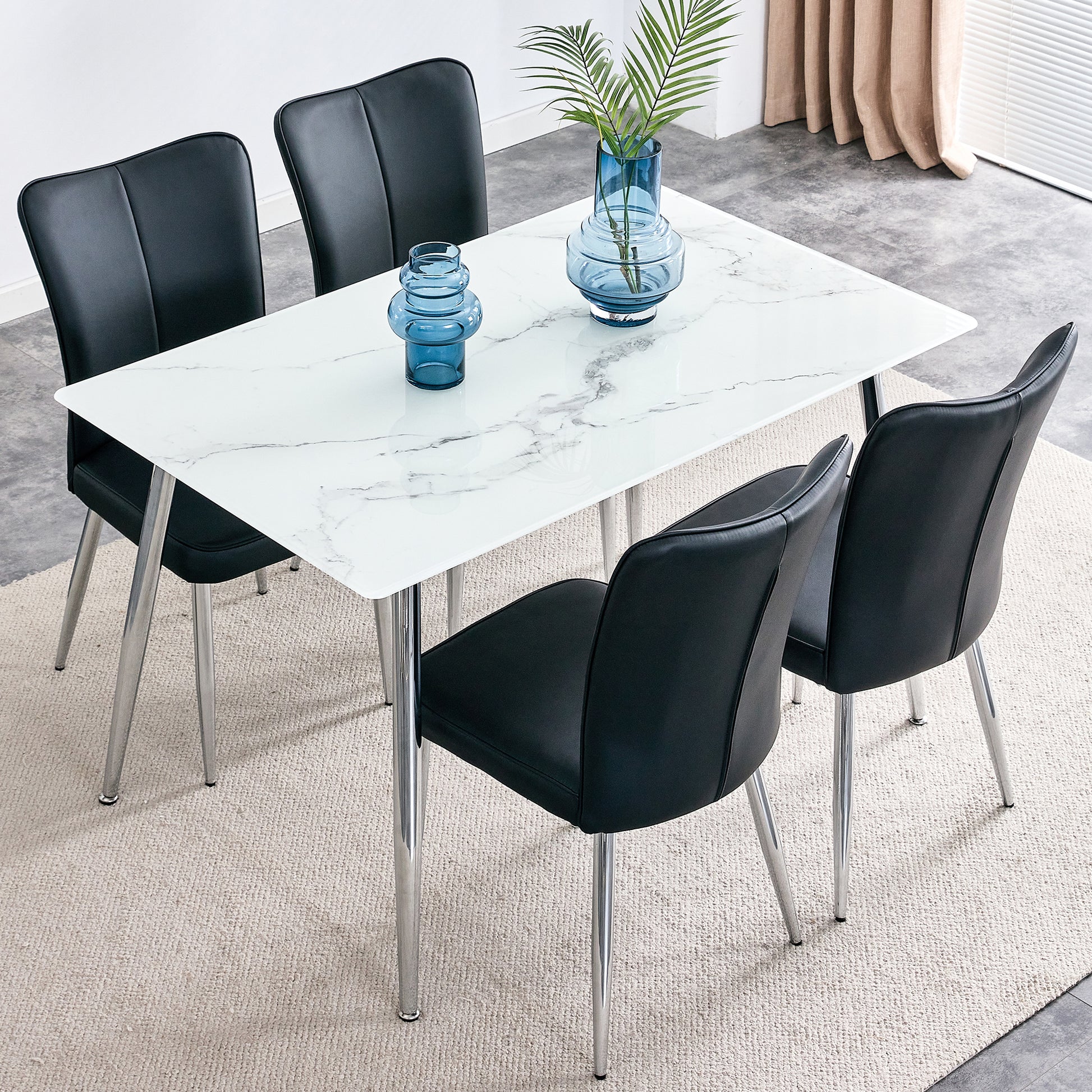 Table and chair set. 1 table with 4 black PU chairs. Modern minimalist rectangular white imitation marble dining table, 0.3 inches thick, with silver metal legs. Paired with 4 PU chairs   DT-1544 008 - Enova Luxe Home Store